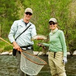 fishing guide and guest proudly hold up caught trout before releasing