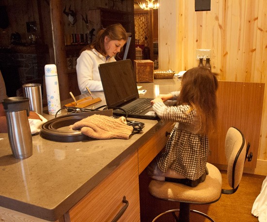 little girl plays receptionist on laptop computer in new reception area