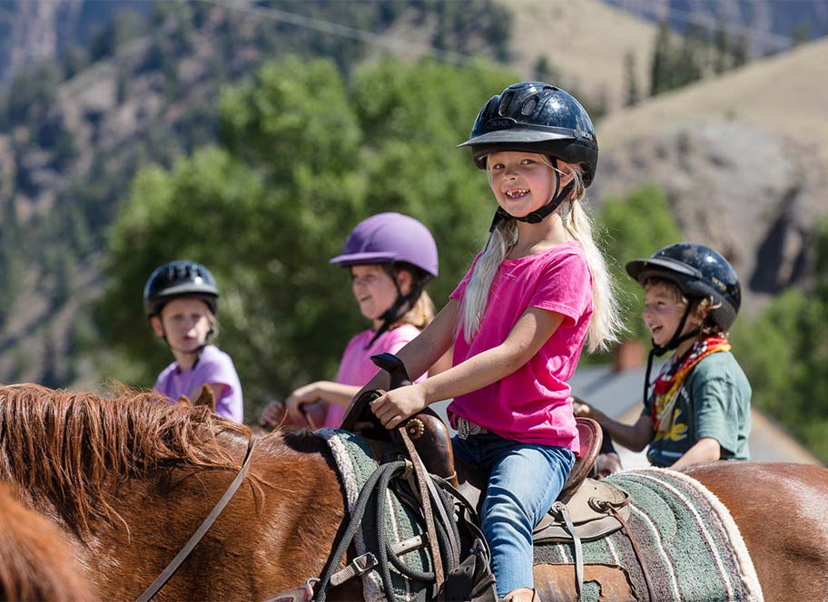 Girls in helmets riding horses
