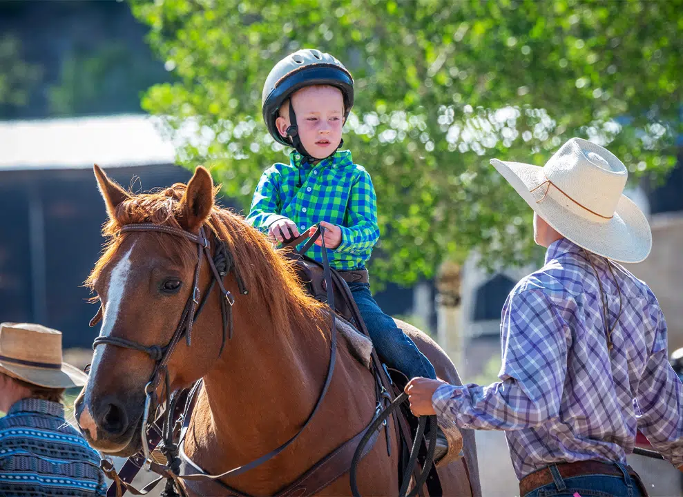 Wrangler briefing child about riding