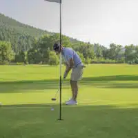 A golfer putts his ball towards the hole