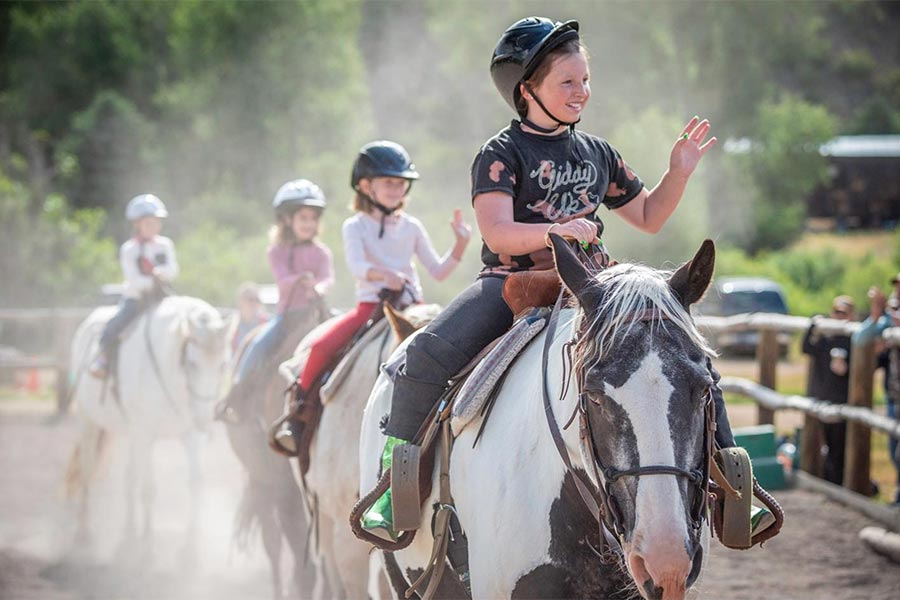 kids on horses in coral