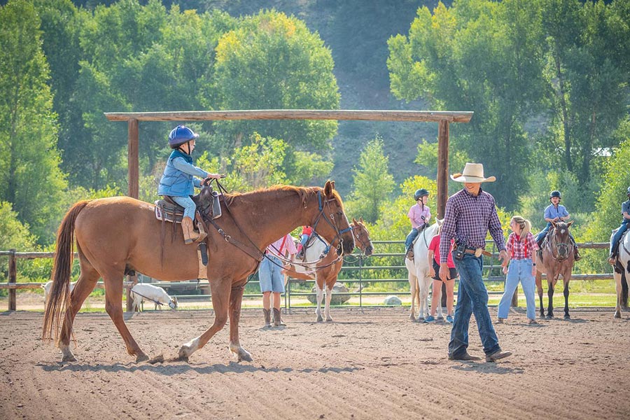 kids on horse in corral